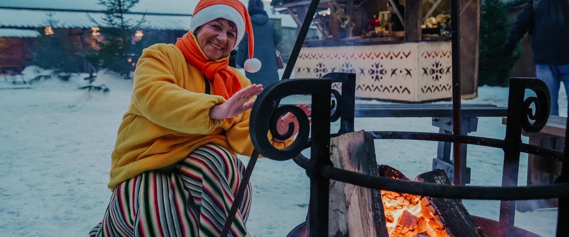 Elf warming themselves by the campfire at the Christmas Village in Narva