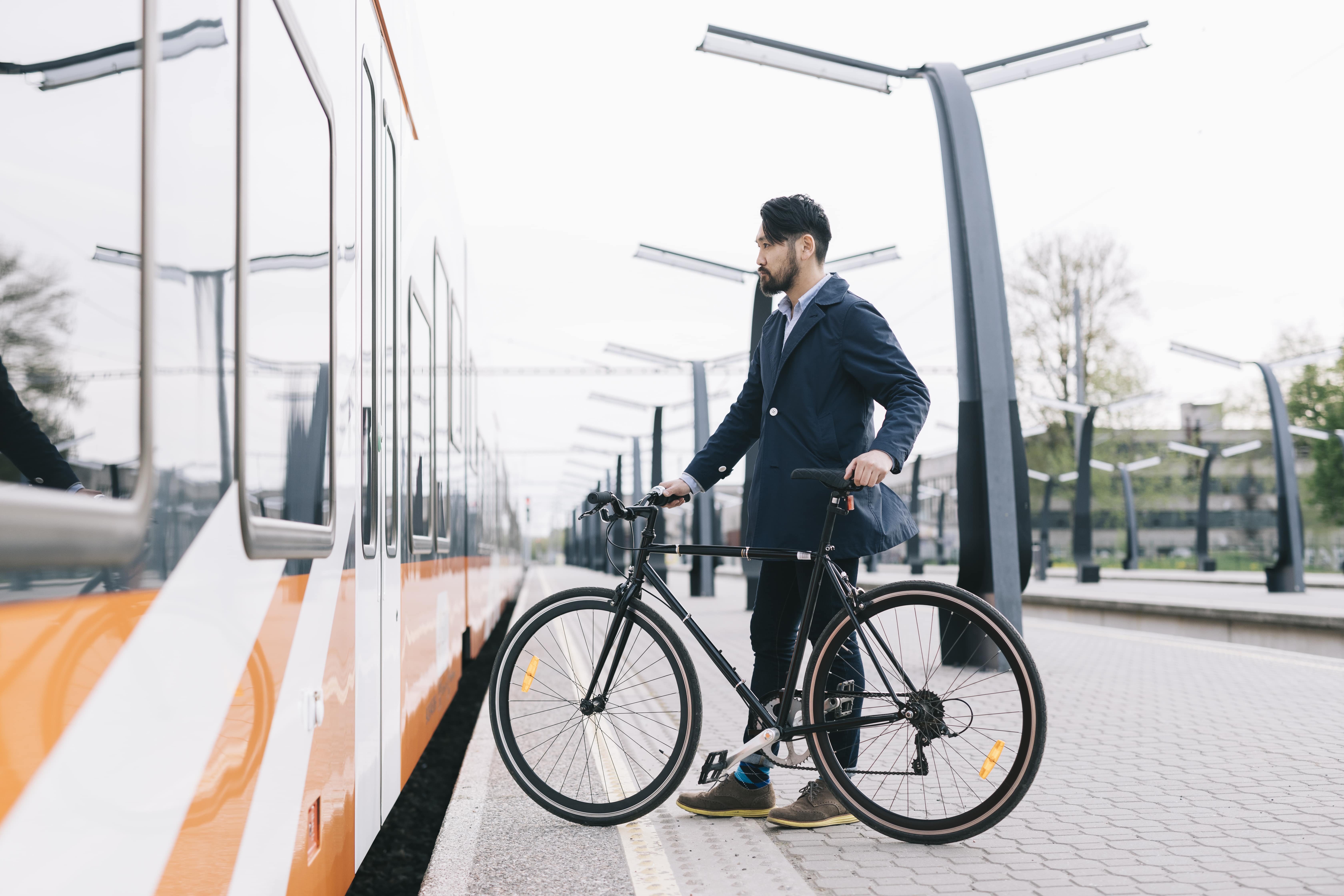 Man waiting to board train with a bike in Tallinn